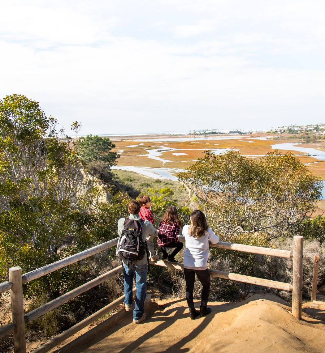 Man, woman and two children overlook the lagoon from the top of Annie's canyon trail