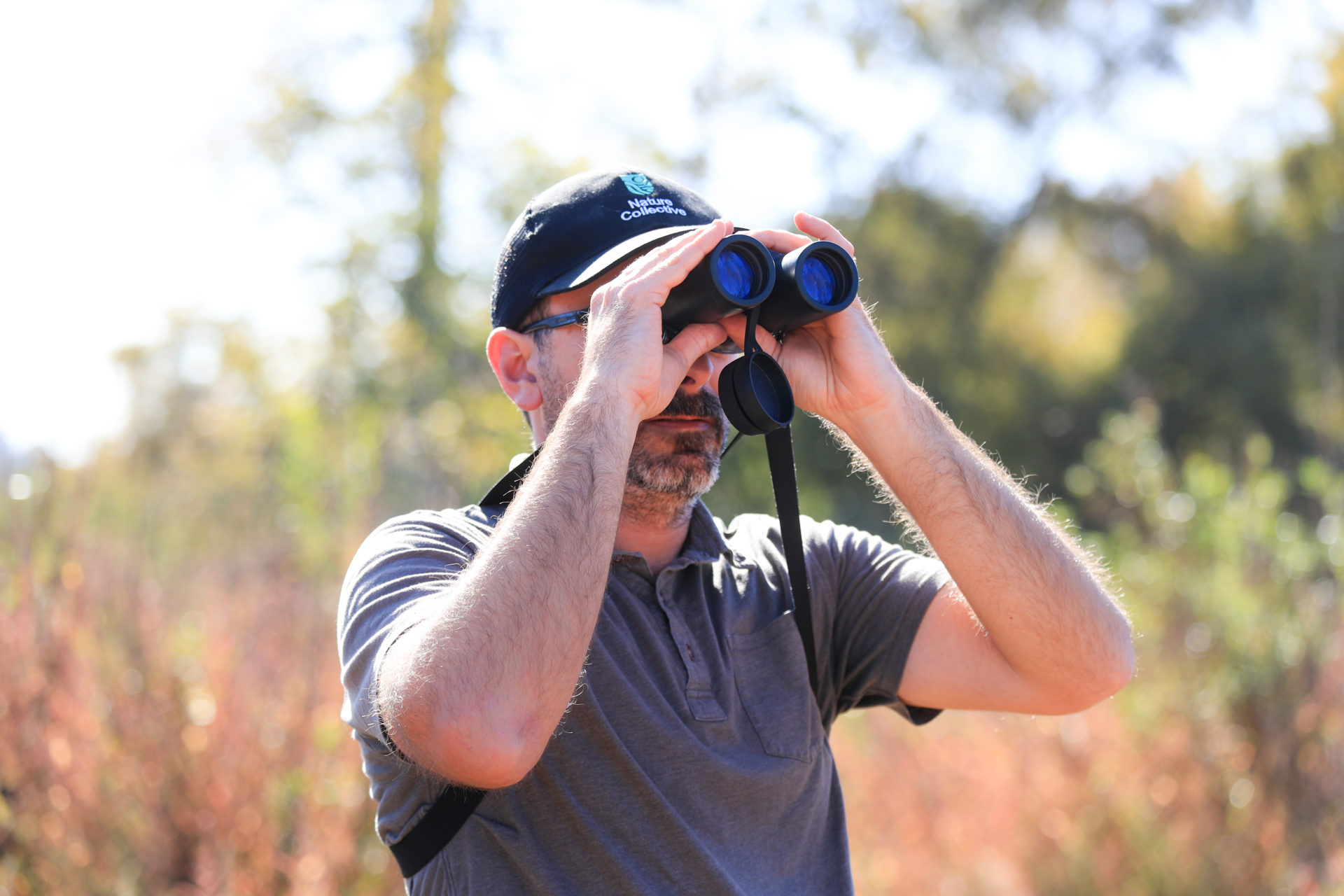 Nature Collective biologist looks through binoculars