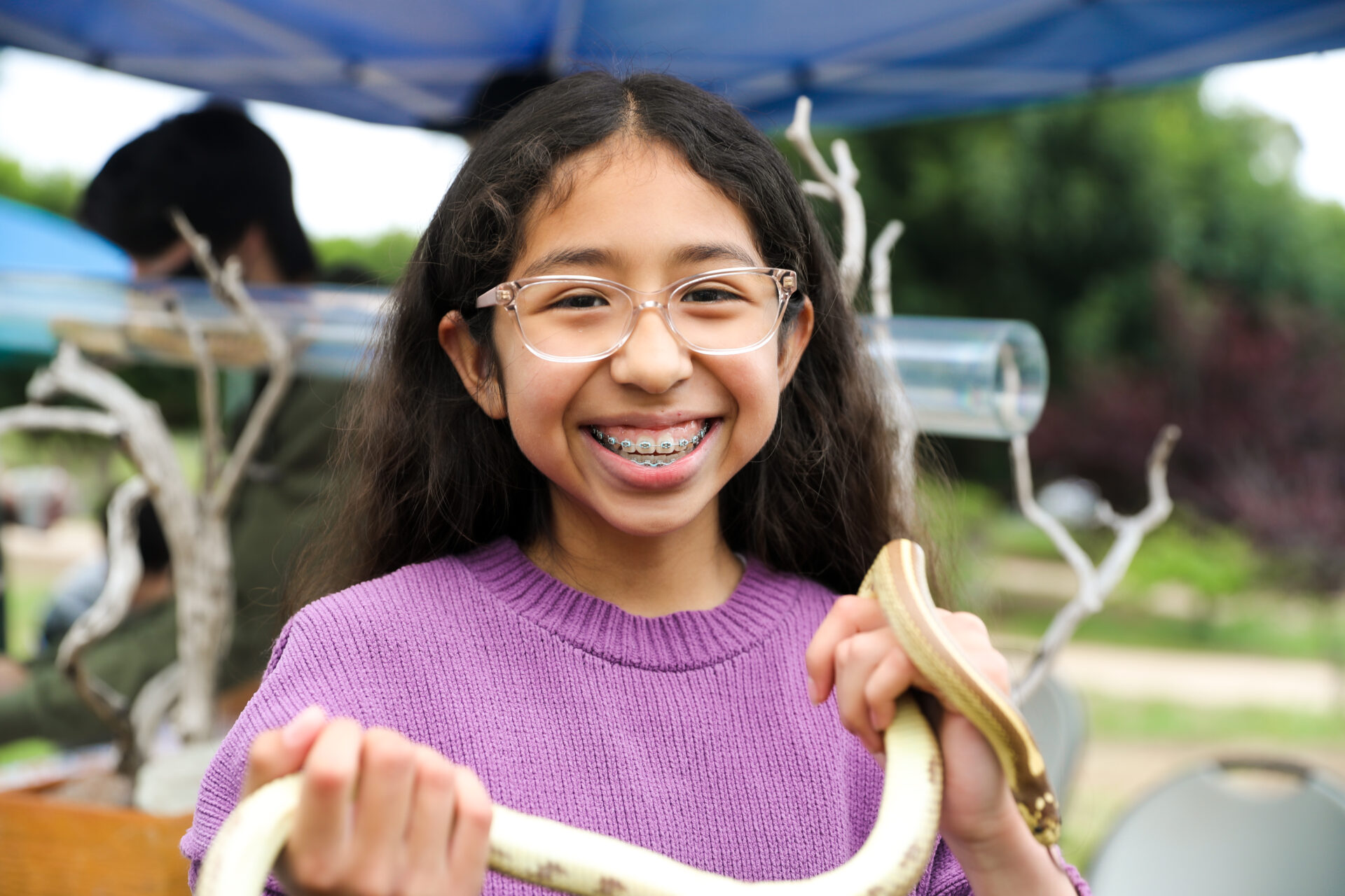 Child smiling and holding a snake