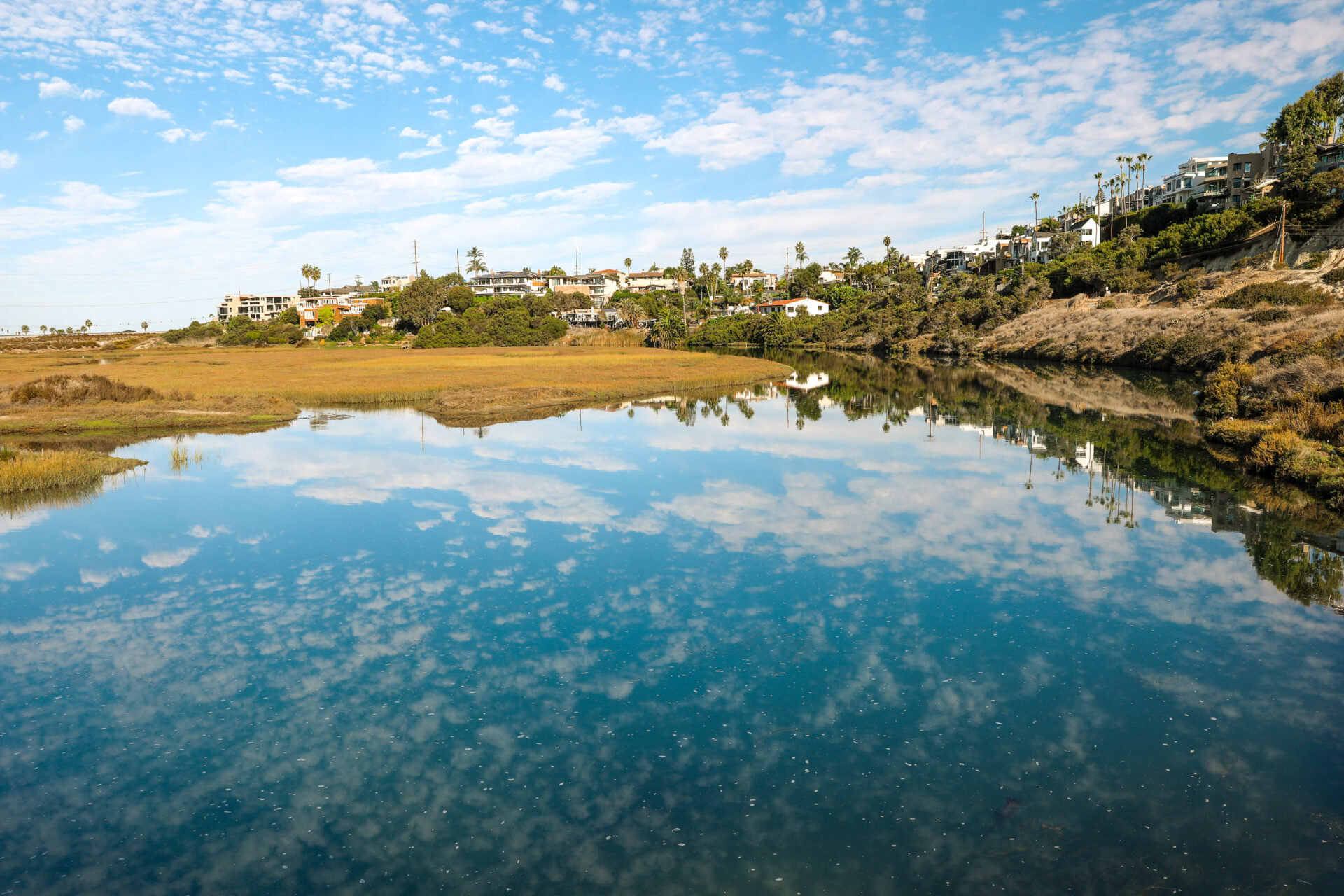 Picture of San Elijo Lagoon Channel, looking blue with the reflection of white clouds in the water
